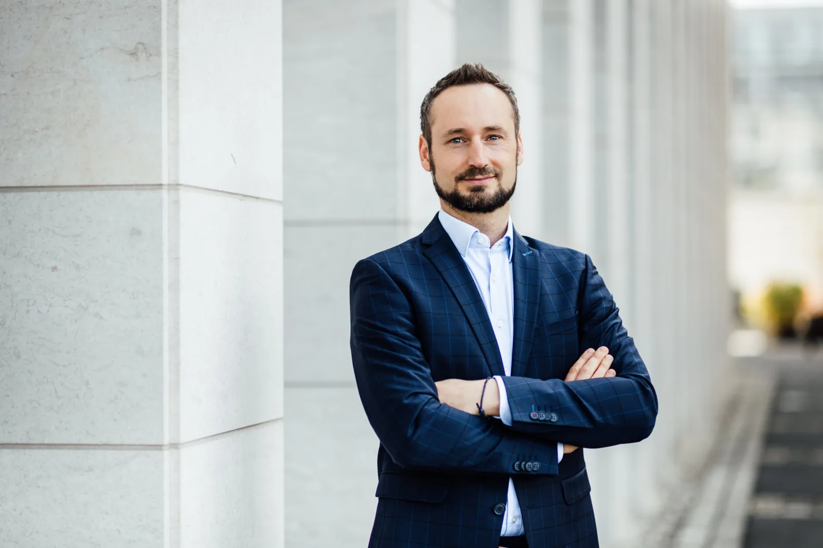 Christian Auer mit verschränkten Armen vor einer hellen Steinfassade