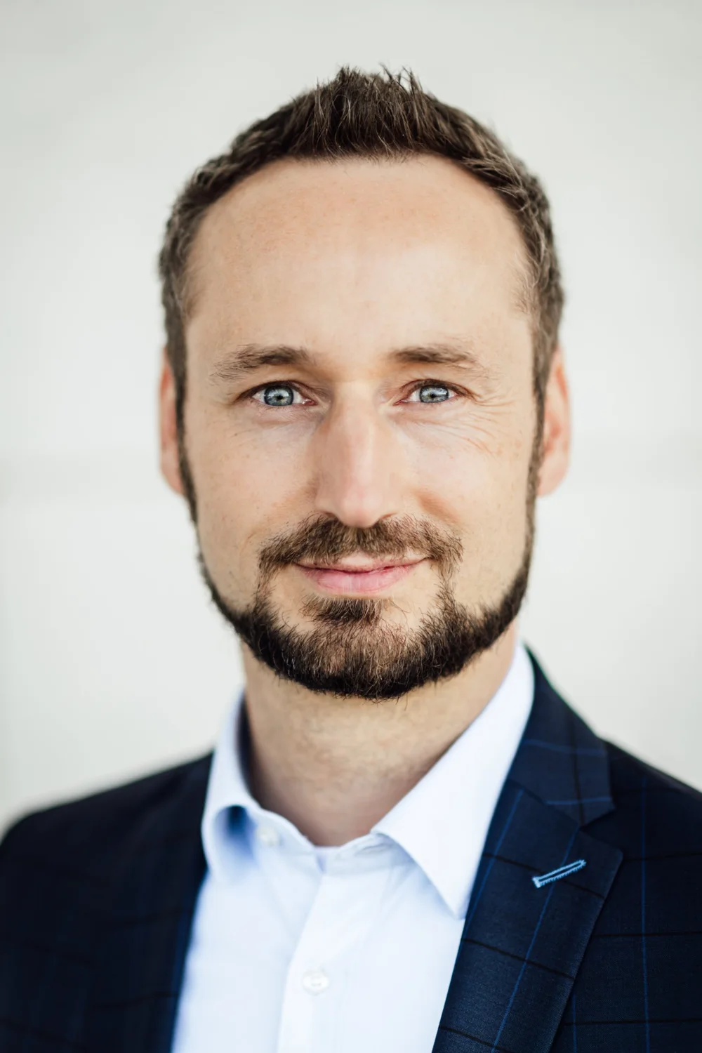 Porträt von Christian Auer im dunkelblauen Sakko